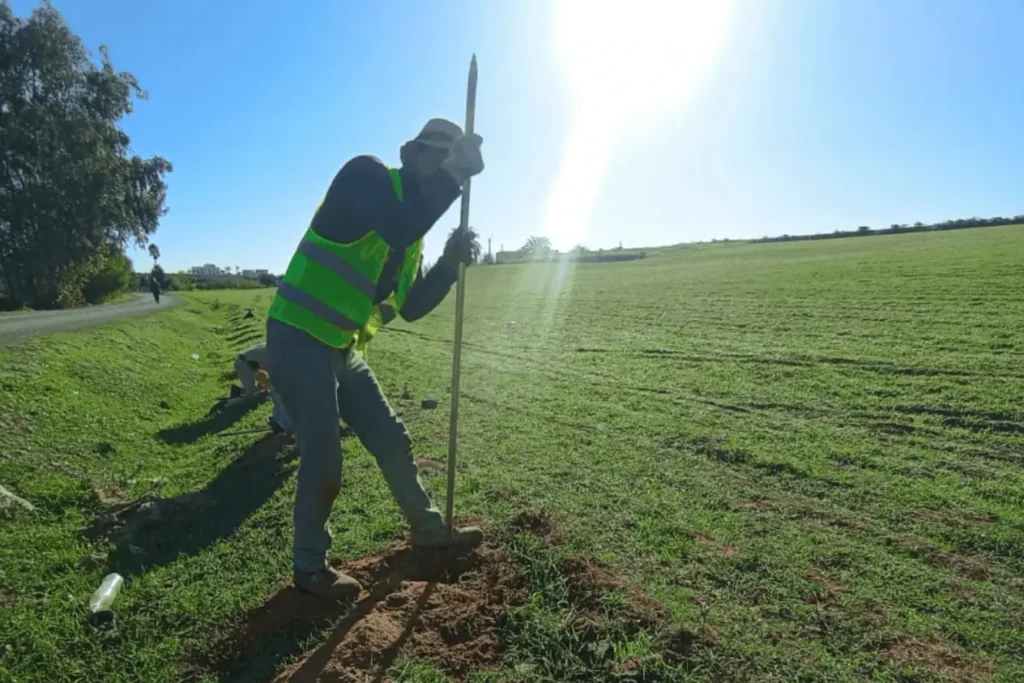 Installation sur le terrain et pose de grillage avec poteau en béton pour délimiter une ferme au Maroc.